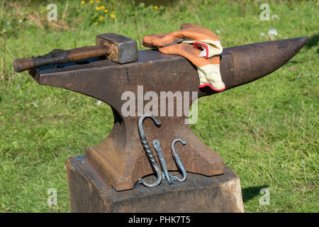 a blacksmiths anvil, gloves and a lump hammer for replacing horse shoes and iron and metalwork. Stock Photo