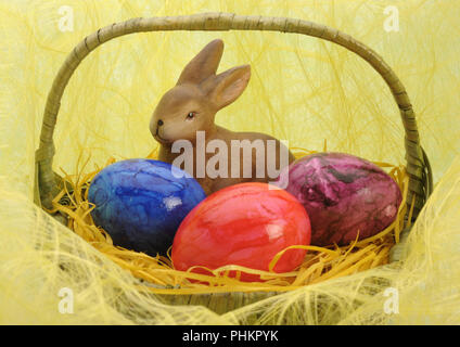bunny and three painted eggs in easter nest Stock Photo
