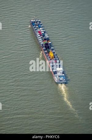 Aerial view, cargo ship on the Rhine goes uphill, push boat with additional lighters, tractors and trucks are the freight, inland navigation Duisburg,