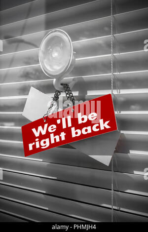 Sign saying We'll be right back on a glass door Stock Photo