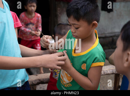 Filipino children partaking in the popular game of spider fighting. Stock Photo