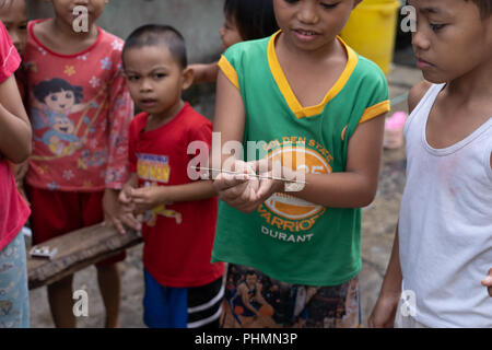 Filipino children partaking in the popular game of spider fighting. Stock Photo