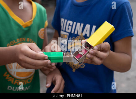 Small boxes with compartments hold individual spiders which are then used by Filipino children partaking in the popular game of spider fighting. Stock Photo