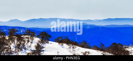 BLue mist over mountains ranges in Kosciuszko national park of Australia in winter season when high country slopes are covered by snow in Perisher val Stock Photo