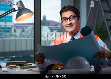 Construction architect working on drawings late at night Stock Photo