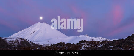 panorama of full moon over the Mount Ngauruhoe during sunrise in winter with pink cloud Stock Photo