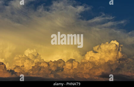 Gorgeous close up view of fluffy cumulus clouds/ Yellow and white clouds during sunset/ Above the clouds/ Sky wallpaper Stock Photo
