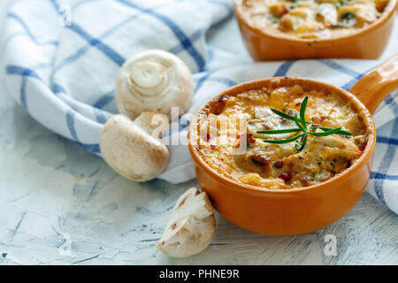 Roasted mushrooms, chicken and cheese gratin in pan. Stock Photo