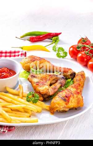 Grilled chicken wings,legs,chips and vegetables Stock Photo
