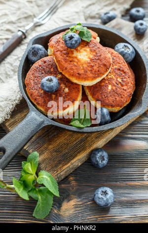 Cheese pancakes and blueberries in cast iron pan. Stock Photo