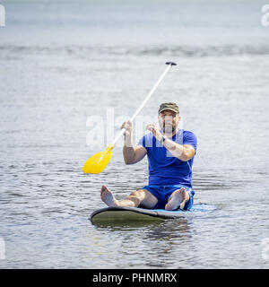 a bearded man paddling in the ocean Stock Photo