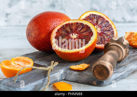 Whole and halves of blood orange and citrus press. Stock Photo