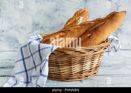 Artisanal baguettes in a wicker basket.