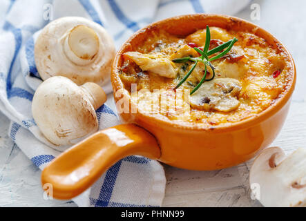 Roasted mushrooms, chicken and cheese gratin in pan. Stock Photo