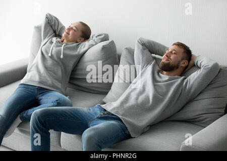 Happy couple relaxing taking nap on cozy sofa at home Stock Photo