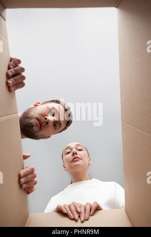 Frustrated couple looking inside parcel disappointed with order Stock Photo