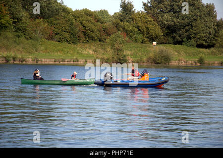 Sale, Manchester, UK. 2 September, 2018. People enjoy outdoor activities in the sunshine at Sale Water Park. A canoe gets a tow on the lake. Credit: Terry Waller Alamy Live News Stock Photo