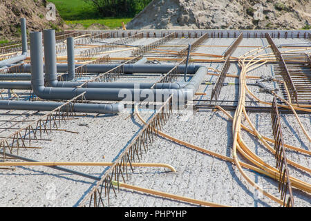 Concrete floor with pipes on construction site Stock Photo