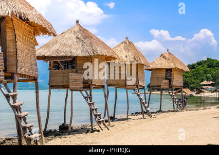Row of Tiki Huts Sunny Beach Vacation Ocean Tropical Living Stock Photo
