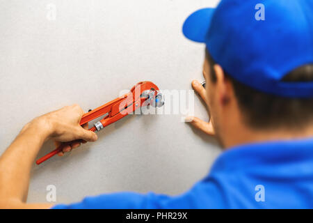 plumber installing water shutoff valve for washing machine at home Stock Photo
