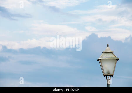 Outdoor retro candelabra street light pole against the bright cloudy sky Stock Photo