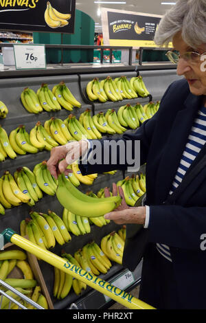 Lady buying bananas at her shopping in Morrisons supermarket aisle, Halfway, Sheffield, England Stock Photo