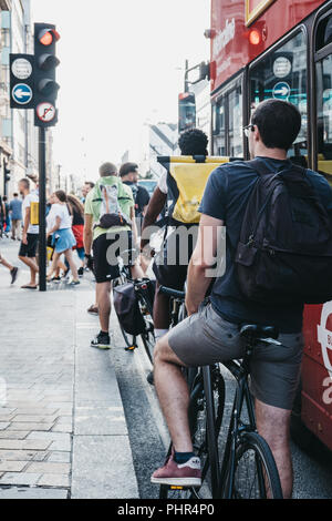 London, UK - July 24, 2018: Cyclists waiting for traffic lights on Oxford Street near entrance to Oxford Circus tube station, the busiest rapid-transi Stock Photo