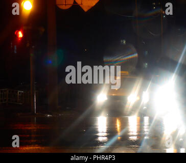 Bright white lights from cars on the night city street blurry abstract background Stock Photo