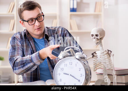 Student and skeleton preparing for school exams Stock Photo