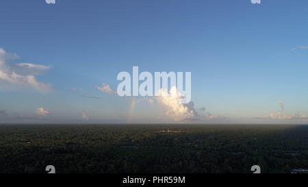 Drone View of Distant Rainbow in Clouds Near Coast Stock Photo
