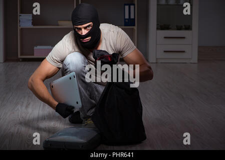 Burglar wearing balaclava mask at crime scene Stock Photo