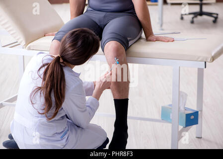 Doctor checking patients joint flexibility with gonimeter Stock Photo