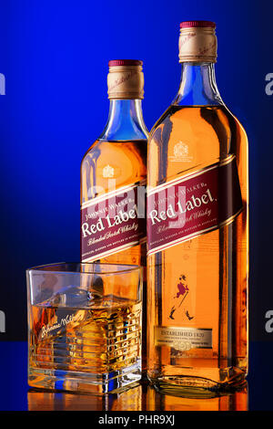 Two bottles of whisky and glass with ice and drink on a blue background Stock Photo