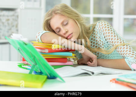 Portrait of a tired schoolgirl sleeping at desk after studying at home Stock Photo