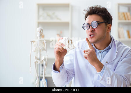 Crazy doctor studying human skeleton Stock Photo