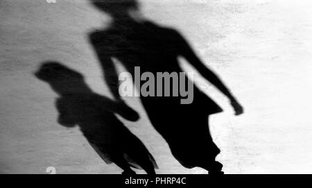 Blurry vintage shadows silhouettes of mother and daughter walking  in black and white Stock Photo