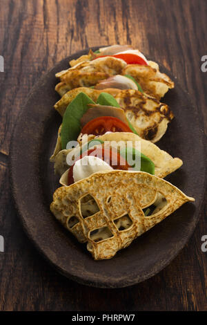 Pancakes sutffed with ham, cheese, tomatoes and spinach Stock Photo