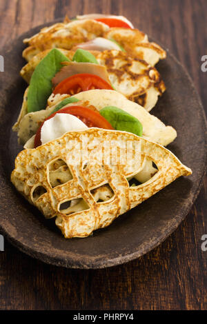 Pancakes sutffed with ham, cheese, tomatoes and spinach Stock Photo