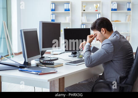 Businessman sitting in front of many screens Stock Photo