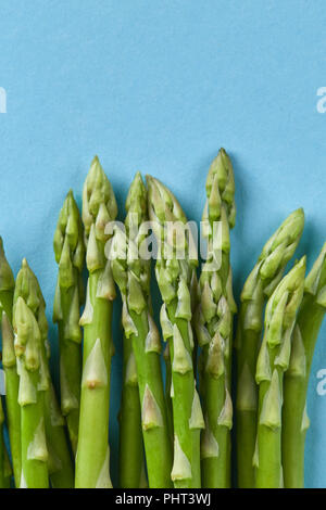 bunch of fresh asparagus stems isolated on blue Stock Photo
