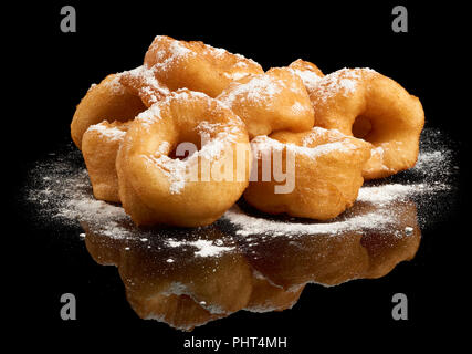 Heap of donuts with sugar powder on black reflective background Stock Photo