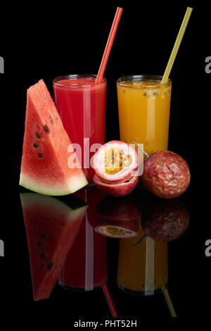 Water melon and maracuya juices and slices on black reflecting background Stock Photo