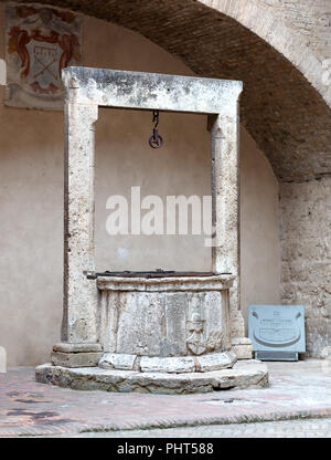 completely stone well under an arch, located in San Gimignano, in the italian tuscany Stock Photo