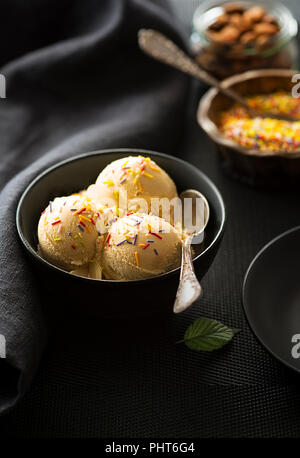 Homemade Organic Vanilla Ice Cream scoops decorated with colorful sprinkles Stock Photo