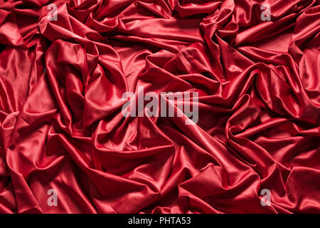 Red silk textured fabric with glitter folded folds with deep shadows Stock Photo