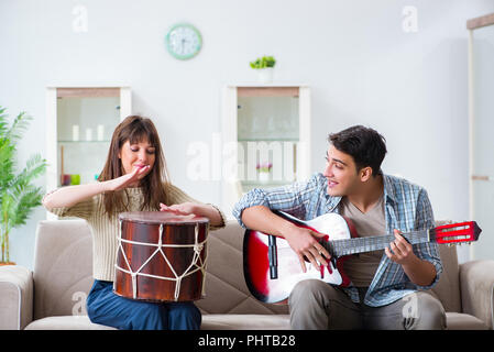 Young family singing and playing music at home Stock Photo