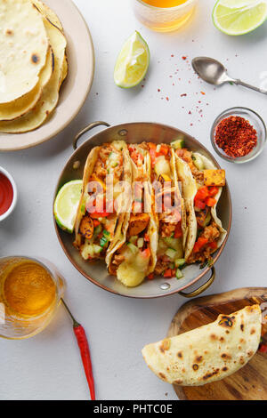 Overhead image of mexican tacos with chili con carne and grated cheese served with lemonade, sauces and toppings Stock Photo