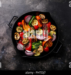 Grilled assorted vegetables in cast iron pan on dark background Stock Photo