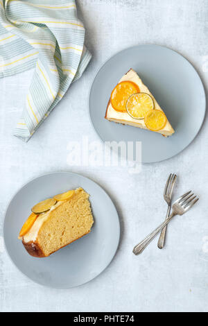 Two slices of orange cake on plates with cake forks. Stock Photo