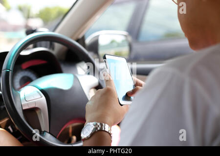 Unidentified man using smart phone while driving Stock Photo